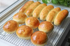 nine rolls on a cooling rack with basil in the background