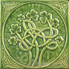 a green tile with four leaf clovers in the shape of a celtic knot on it