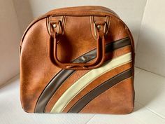 a brown and white striped purse sitting on top of a table next to a wall