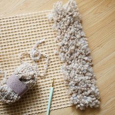 a pair of knitting needles and yarn on a mat