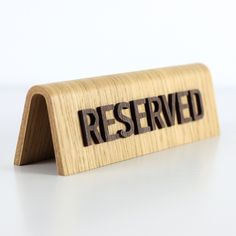 a wooden business card holder with the word reserved on it