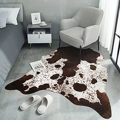 a bedroom with a cow hide rug on the floor next to a chair and bed