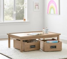 two storage boxes sit on the floor in front of a coffee table with an open drawer