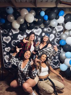 four women posing for a photo in front of balloons