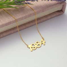 Introducing our Custom Year Necklace, the perfect personalized piece to commemorate a special date or milestone in your life! Handcrafted with love and attention to detail, this necklace features a delicate chain and a dainty pendant engraved with the year of your choice. Whether it's a birth year, anniversary, or any significant event, this necklace is a timeless keepsake to cherish for years to come. Treat yourself or surprise a loved one with a thoughtful and unique gift that will be treasure Vintage Personalized Name Necklace For Anniversary, Personalized Vintage Name Necklace For Anniversary, Anniversary Name Necklace, Year Necklace, Date Necklace, Number Necklace, Dainty Pendant, Birth Year, Lucky Number