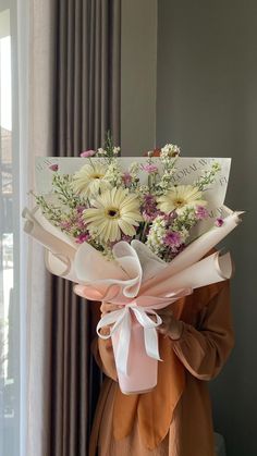 a woman holding a bouquet of flowers in her hands