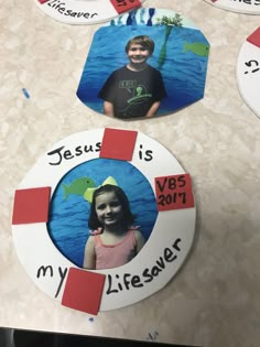 two children's pictures are placed on the table with magnets attached to them that say jesus is my lifesaver