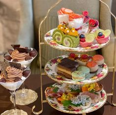 three tiered trays filled with different types of desserts and pastries on top of each other