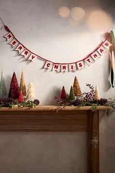 a mantle with christmas decorations and garland on it