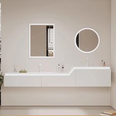 a white bathroom with two sinks and mirrors on the wall next to each other in front of a window