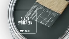 a paint can with a brush in it and the words black evergreen painted on it