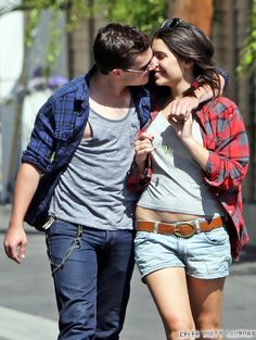 a young man and woman walking down the street