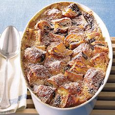 a baked dish with powdered sugar on top next to a spoon and napkins