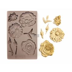 a cookie sheet with flowers and leaves on it, next to the cookie molds