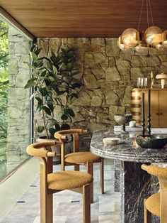 a dining room with stone walls and wooden chairs