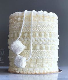 a white cake sitting on top of a counter next to a bag with some sugar cubes in it