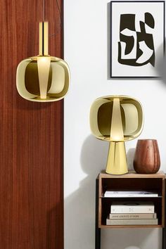 a living room with a table and two lamps on the wall next to a book shelf