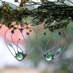 Mushrooms earrings Hearts made from copper wire, tin-copper alloy and green glass. All elements are handmade, which ensures the individuality of each product made in the Yadovito workshop. Polished with a finishing solution to give the jewelry a noble appearance and at the same time so that the metal does not oxidize. The earrings use glass melted in a special furnace. After melting, the glass takes on an almost unique shape and amazing color shades that play in the light. Size about 4.5 cm/4.5 Whimsical Wire Wrapped Metal Earrings, Handmade Metal Fantasy Earrings, Handmade Fantasy Metal Earrings, Whimsical Green Heart-shaped Jewelry, Handmade Green Fantasy Earrings, Bohemian Handmade Sterling Silver Heart Earrings, Handmade Bohemian Sterling Silver Heart Earrings, Mushrooms Earrings, Jewelry Mushroom