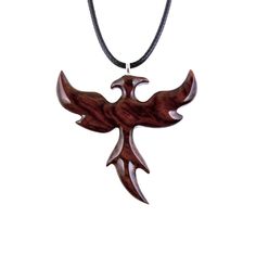 a wooden bird pendant on a black cord with an eagle symbol hanging from it's side