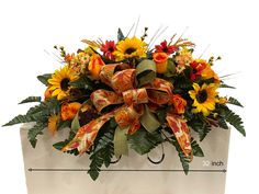 a bouquet of sunflowers and other flowers in a white box with a measuring line