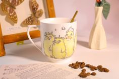 a coffee cup sitting on top of a table next to a pile of nuts and paper