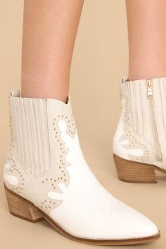 These exclusive Wild West Wonder Ivory Boots combine upscale style with rustic charm. Their intricate Western embroidery, refined stitching, and sturdy construction create a luxurious look that's perfect for your style statement. Step into the Wild West with these timeless boots, crafted with sophistication and luxury in mind. These ankle boots feature a pointed toe, a side zipper closure, a stretchy side panel, embroidered detailing, and a stacked heel. • Heel measures 2" • Man Made Materials • Cream Western Boots For Fall, Cream Snip Toe Boots For Fall, Western Cream Heeled Boots For Spring, Cream Western Heeled Boots For Spring, Chic Off White Boots For Fall, Western Cream Snip Toe Heeled Boots, Western Cream Heeled Boots With Snip Toe, Western Cream Heeled Boots With Round Toe, Western Cream Ankle Boots