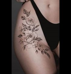 a woman's thigh with flowers and leaves tattoo on her side ribcage