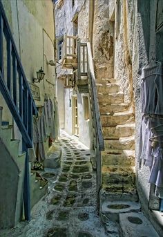 an alley way with stone steps leading up and down