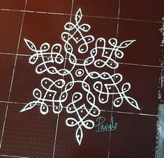 a white snowflake drawn on the ground in front of a brown tiled floor