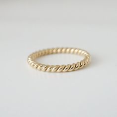 This is our Brockton Signature 2 mm rope ring in solid 14k yellow gold.  It is handmade to order in Toronto.  We love it because it is so versatile.  It looks great on its own and pairs nicely with an engagement ring or classic ring stack.  Also available for custom order in different widths.  Please ask for details.  MATERIALS14k yellow gold.SIZEThe ring will be custom made in your size.  Size 6 ring is in-stock and available and ready to ship immediately.  Additional fee may apply larger sizes Braided Gold Wedding Band, Twisted 14k Gold Ring, Yellow Gold Twisted Ring For Gift, Twisted Yellow Gold Ring For Gift, Twisted Yellow Gold Ring As Gift, Modern Twist Yellow Gold Twisted Stackable Rings, Twisted 14k Gold Rings With Modern Twist, Modern Twist 14k Gold Twisted Ring, Minimalist 14k Gold Spiral Ring