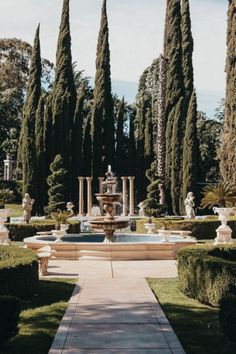 an outdoor fountain surrounded by trees and bushes