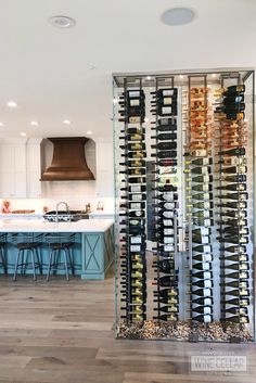 a wine rack in the middle of a kitchen with blue cabinets and stools next to it