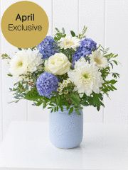 a blue vase filled with white and blue flowers