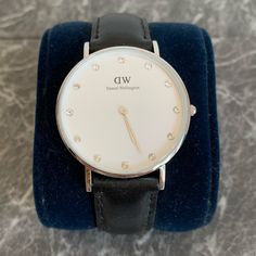 Daniel Wellington Women's 0960dw Classy St Mawes Stainless Steel Watch With Crystal Markers About This Item Round Watch Featuring Logoed White Dial With Crystal Indices 34 Mm Stainless Steel Case With Mineral Dial Window Quartz Movement With Analog Display Leather Calfskin Band With Buckle Closure Water Resistant To 30 M (100 Ft): In General, Withstands Splashes Or Brief Immersion In Water, But Not Suitable For Swimming. Classic White Diamond Analog Watch, Formal White Leather Strap For Watches, Luxury White Watch For Everyday Wear, Luxury White Watch For Everyday, Luxury White Watches For Everyday, Classic Silver Leather Diamond Watch, Classic Silver Diamond Watch With Leather Strap, Timeless Watches With Diamond Hour Markers And Adjustable Fit, Classic White Watch For Work