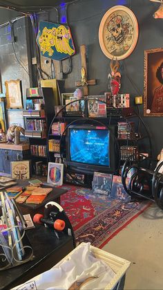 a living room filled with lots of clutter and furniture next to a wall mounted tv