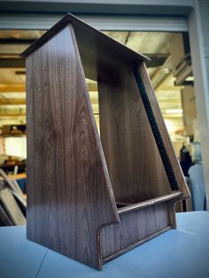 a wooden book case sitting on top of a table