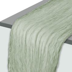 an image of a green blanket on the edge of a bed