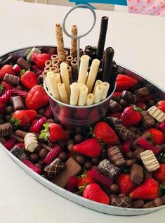 a platter filled with chocolate, strawberries and pretzel sticks in it