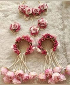 some pink flowers and pearls on a white fur