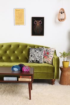 a living room with a green couch and coffee table