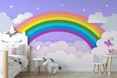 a child's bedroom with a rainbow wall mural