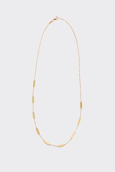 a gold necklace on a white background