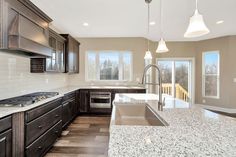 a large kitchen with granite counter tops and wooden cabinets, along with stainless steel appliances