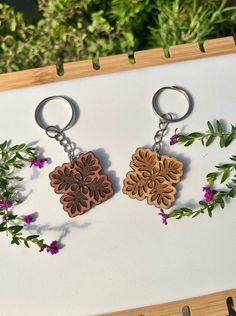 two wooden key chains with flowers on them