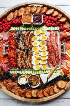 a platter filled with meats, eggs, sausages and other food items