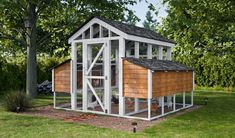 a chicken coop in the middle of some grass