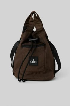 Cross Body Bucket Bag - Espresso/Black | Alo Yoga Everyday Utility Bag With Removable Pouch, Functional Rectangular Bucket Bag For On-the-go, Functional Bucket Bag For On-the-go, Functional Crossbody Bucket Bag For Daily Use, Everyday Nylon Utility Bag, Everyday Utility Nylon Bag, Functional Large Capacity Bucket Bag For Daily Use, Utility Nylon Bag With Adjustable Strap, Utility Bags With Adjustable Strap For Daily Use