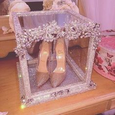 a pair of high heeled shoes sitting in front of a mirror on top of a table