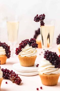 cupcakes with white frosting and blackberries on top