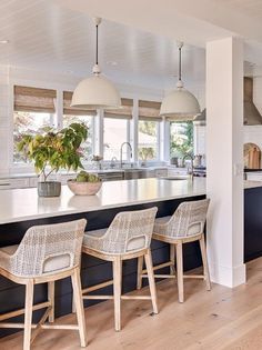 a kitchen with an island and four stools in front of the countertop area